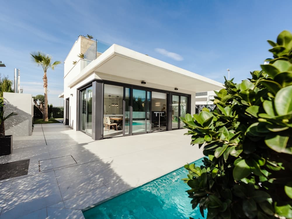 Modern detached studio ADU with floor-to-ceiling glass and a low flat roof